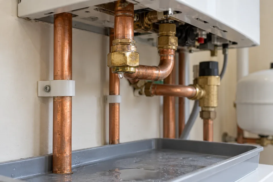Illustrative water droplet at a copper heating-pipe connection above a collection tray